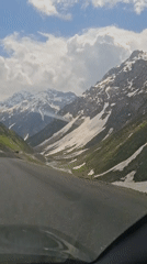 Vehicle crosses snowy mountain pass in Tajikistan
