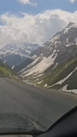 Vehicle crosses snowy mountain pass in Tajikistan