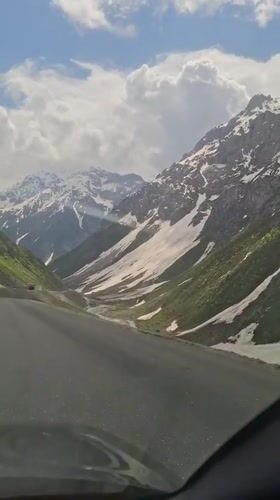 Vehicle crosses snowy mountain pass in Tajikistan