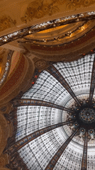 Tourist documents famous Galeries Lafayette dome in Paris