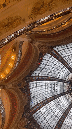 Tourist documents famous Galeries Lafayette dome in Paris