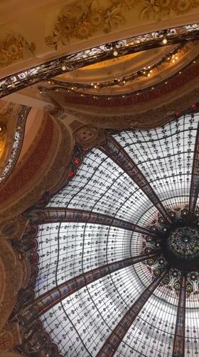 Tourist documents famous Galeries Lafayette dome in Paris