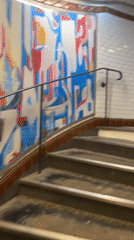 Witness documents subway station staircase ascent with decorative murals