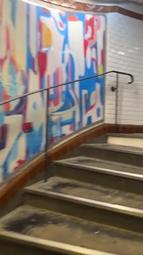 Witness documents subway station staircase ascent with decorative murals