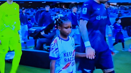Child escorts walk with players during pre-match ceremony