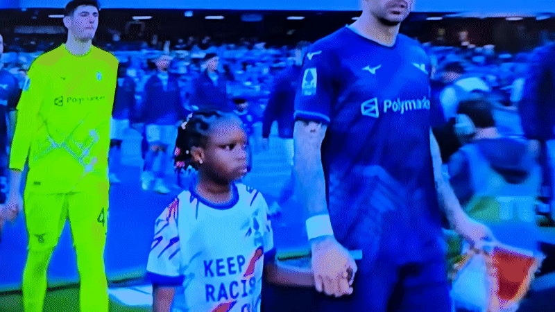 Child escorts walk with players during pre-match ceremony