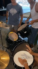 Three-person drum session on a black kit in Washington Township