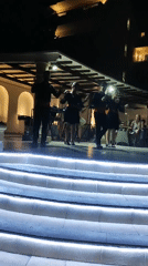 Outdoor dance performance on a lit stage in Rhodes at night