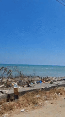 Indonesian coastal village scenes: water, boats, and shoreline debris