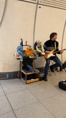 Street musician performs with puppet cart in London subway
