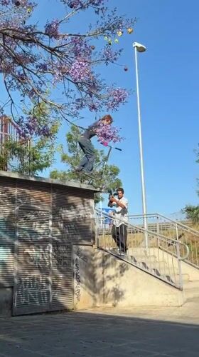 Person prepares scooter ride from graffitied building in Badalona