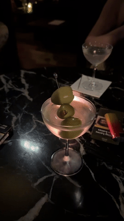 Martini and cigarettes on a black marble bar table