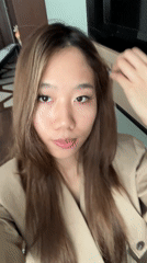 Woman takes bathroom selfies in tan trench coat, Lanzhou