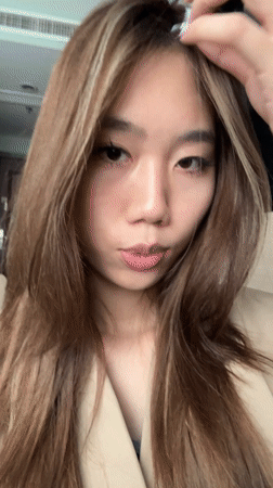 Woman takes bathroom selfies in tan trench coat, Lanzhou