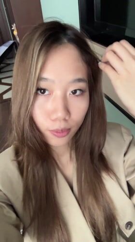 Woman takes bathroom selfies in tan trench coat, Lanzhou