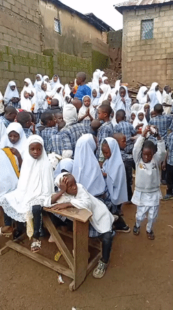 Community gathering in traditional dress at an outdoor village setting
