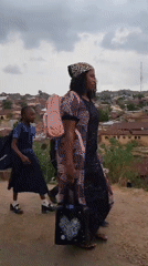 Injured man walks with crutches overlooking Jos village