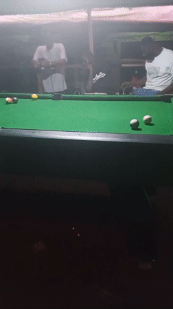 Men play pool at night recreation venue in Lokoja