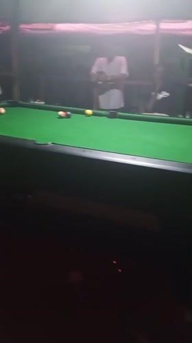 Men play pool at night recreation venue in Lokoja