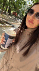 Woman enjoys morning coffee walk along sunny Sochi promenade