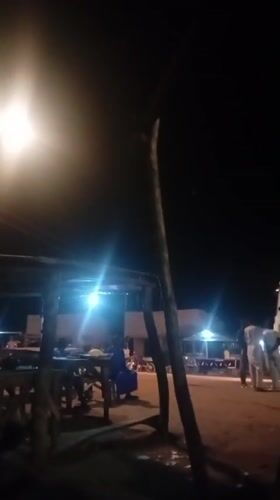 Night gathering near lit shelter and motorcycles in northern Nigeria
