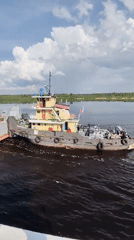 Tugboat tows barge through Russian waterway near Kochino
