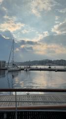 Sailboat docked at Nessebar waterfront under partly cloudy skies