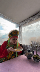 Woman enjoys traditional Russian meal on porch in Chaikovsky