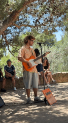 Street musician performs near Park Güell on sunny Barcelona afternoon