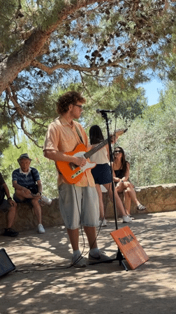 Street musician performs near Park Güell on sunny Barcelona afternoon