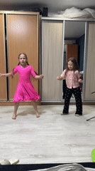 Two girls dance together in bedroom in Rusalevka, Russia