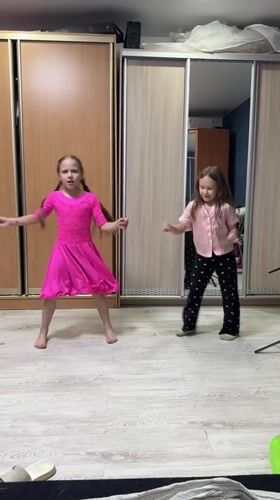 Two girls dance together in bedroom in Rusalevka, Russia