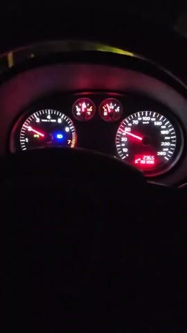 Here is a forensic description of the video:

The video shows a driver's perspective from inside a car at night. The dashboard is visible, displaying the speedometer, tachometer, and other gauges. The speedometer reads approximately 80 km/h, and the tachometer shows the engine speed. The odometer reads 236.6 km. Streetlights and trees are visible through the windshield, indicating the car is traveling on a road in what appears to be a residential area. Music is audible in the background. The driver is holding the steering wheel, and the focus remains on the dashboard and the view through the windshield.