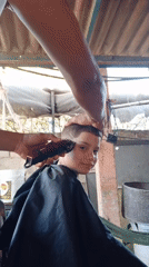 Boy gets outdoor haircut with design in Porlamar, Venezuela