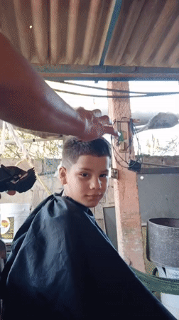 Boy gets outdoor haircut with design in Porlamar, Venezuela
