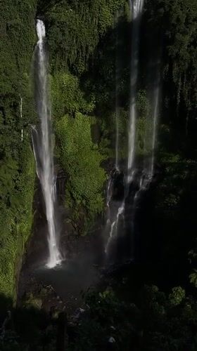 Multi-tiered jungle waterfall in Sawan, Indonesia, from above and below
