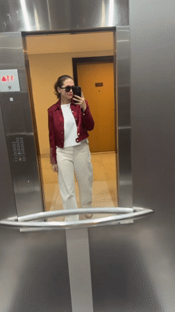 Woman in red jacket moves through Dubai building locations