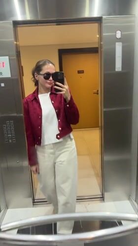 Woman in red jacket moves through Dubai building locations