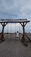 Visitor enjoys swing set at Serbian restaurant location