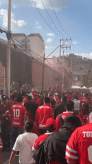 Toluca football fans gather in red jerseys with smoke bombs