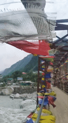 Prayer flags flutter over a mountain river in Kalath, India