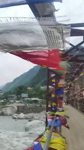 Prayer flags flutter over a mountain river in Kalath, India