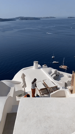Oia rooftops, Aegean views, and a hat stall on a July morning
