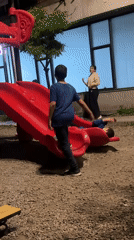 Children play on playground equipment at night in Yerevan