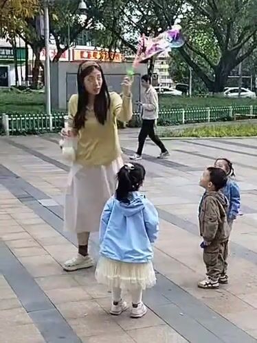 Woman blows bubbles for children in Yuzhong District