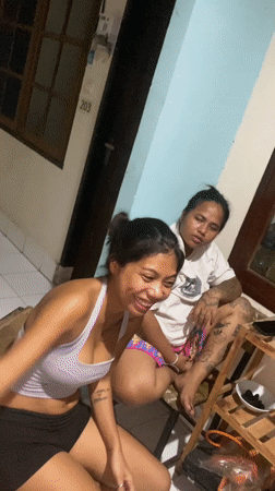 Two women socialize at Kuta guesthouse during evening hours