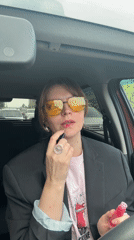 Woman applies makeup in driver's seat during early morning