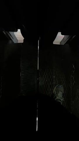 The video shows a person standing with their feet visible in what appears to be an elevator or a similar enclosed space. The floor is metallic and appears to be a grated diamond plate pattern. The lighting is dim, with some light filtering in from above. The person is wearing athletic shoes. The video captures a brief moment of stillness before the perspective shifts slightly, suggesting movement.
