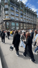 Pedestrians gather near historic Singer House on Saint Petersburg street