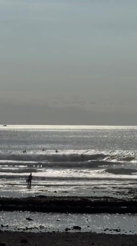 Surfers gather on a Tenerife beach on a July afternoon